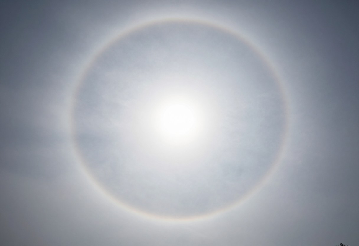 Photo-style AI-generated image of a thin milky cloud veil with a bright halo ring around the sun