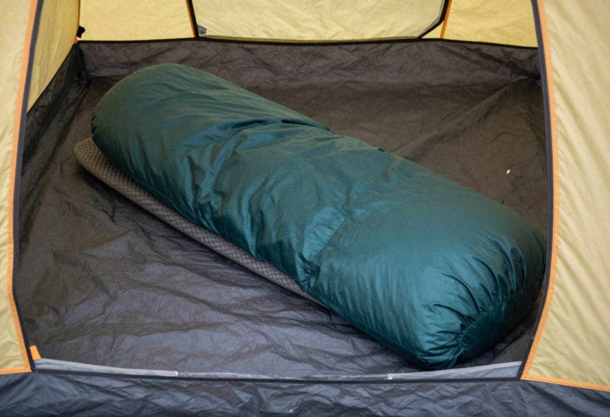 A sleeping pad and sleeping bag set up neatly inside a tent